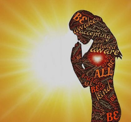 sihouette of woman in prayer position in front of the sun