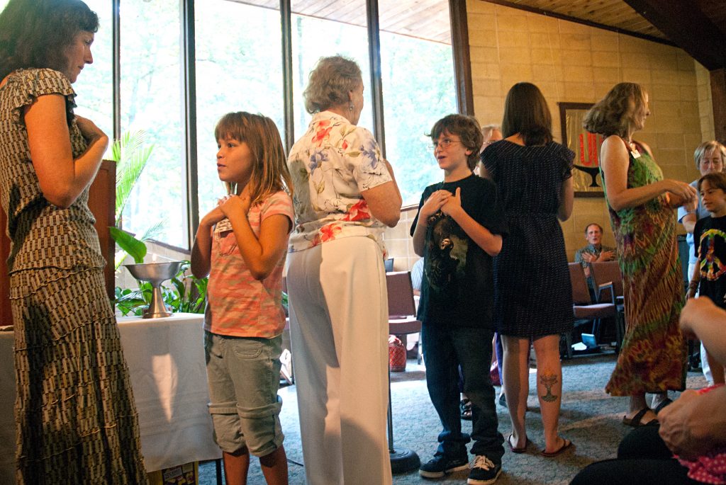 Children and adults facing each other in partners for song