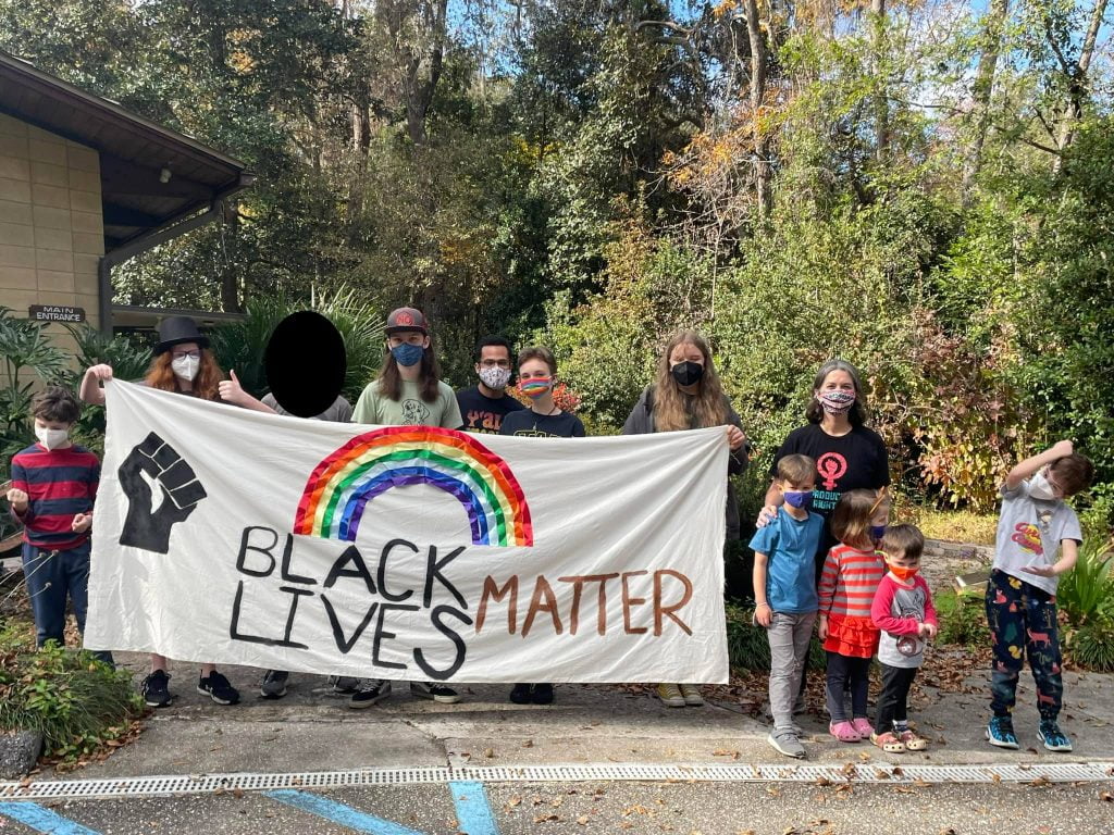 Children, youth and adult leaders holding their Black Lives Matter banner