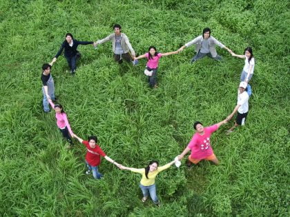 people holding hands in a heart shaped circle